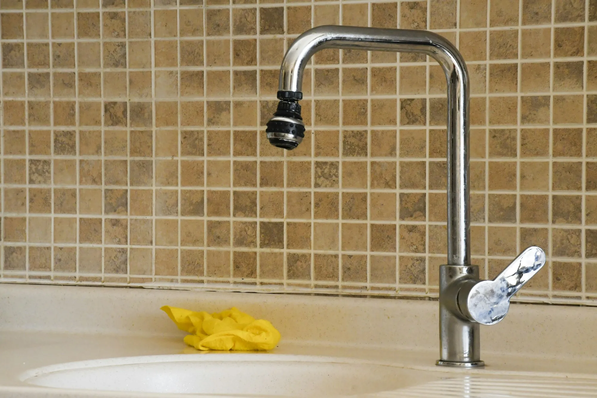 Kitchen sink with a faucet and a yellow sponge