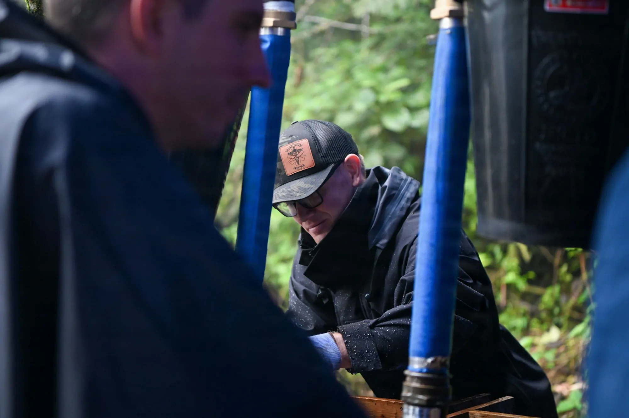 Local Water Specialists, Not a Sales Floor Man in a cap working with blue hoses outdoors